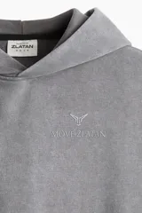 Buzo deportivo sin mangas en color gris con efecto lavado. Modelo de corte holgado con capucha forrada cruzada, bolsillo canguro y diseño reflectante en pecho y espalda. Remate acanalado ancho en el bajo. Interior cepillado suave.