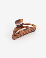 Broche para el pelo color marrón carey con forma de semicírculo calado.