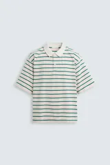 Polo relaxed fit a rayas horizontales color verde y blanco, confeccionado en tejido con mezcla de algodón y viscosa. Cuello solapa con cierre frontal de botonadura y manga corta.