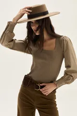 Top negro de calce al cuerpo con escote cuadrado amplio. Mangas largas abullonadas con puños elastizados.