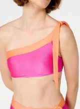 Bikini de dos piezas marca Blueman, con corpiño asimétrico de un solo hombro y bombacha de tiro alto con lazos laterales. Diseño color fucsia con detalles en naranja.