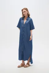 Vestido largo camisero de lyocell azul denim, corte holgado, con cuello camisero, mangas cortas con dobladillo y cierre frontal con botones.