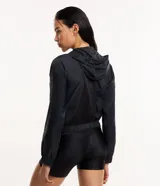 Campera rompevientos deportiva color blanco, confeccionada en poliamida, con capucha, cierre delantero en cremallera, tirador gomoso y puños ajustados.