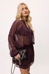 Vestido corto color verde lima, estilo camisero, confeccionado en chiffon transparente. Tiene cuello camisero, mangas largas abullonadas y elástico en la cintura.