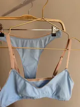 Conjunto de ropa interior celeste, compuesto por un corpiño de algodón con breteles finos y una bombacha clásica con elásticos beige.