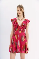 Vestido mini color fucsia con estampado de hojas multicolor, escote en V con volados, sin mangas y falda acampanada.