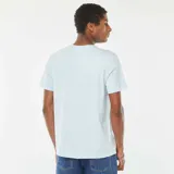 Camiseta celeste con estampado de la película Jaws (Tiburón) con el texto "Visit Amity Island" y el logo del 50 aniversario. 