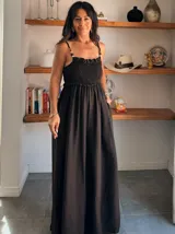 Mono largo negro de tejido crepé, con escote fruncido y tirantes finos decorados con cuentas.