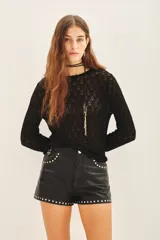 Remera negra de tejido calado con lurex, corte ajustado y mangas largas.