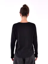 Buzo negro de tejido de punto con cuello redondo y mangas largas, decorado con apliques de strass en el canesú.