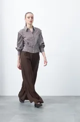 Pantalón ancho (wide leg) de color marrón oscuro, con calce fluido y lazo regulable en la cintura.