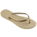 Sandalias Havaianas Slim Glitter II color beige con tiras finas con glitter dorado.