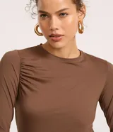 Blusa manga larga godê color borgoña, confeccionada en microfibra con fruncido en los hombros y laterales.