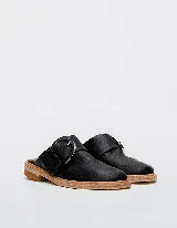 Mocasines negros de cuero con hebilla plateada y suela de cuero color natural.