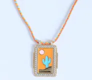 Collar dorado con dijes rectangulares con diseños esmaltados de sol, cactus y planeta, y dije de corazón con strass.