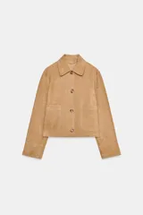 Chaqueta corta de ante color camel, con cuello clásico, cierre frontal con botones, mangas largas y dos bolsillos de parche en la parte delantera.