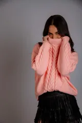 Sweater color crudo con cuello alto y diseño trenzado.