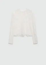Blusa blanca de encaje floral semitransparente, con cuello redondo, mangas largas y cierre de botones en la nuca.