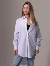 Camisa celeste y blanca a rayas verticales, de corte amplio y mangas largas.