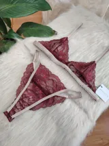 Conjunto de lencería de encaje color borgoña, compuesto por un bralette con breteles regulables y una tanga regulable de corte media less con entrepierna de algodón.