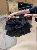 Minifalda amarilla con textura arrugada y múltiples volantes.