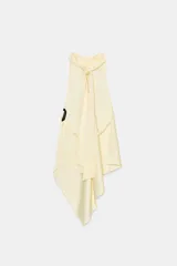 Top sin mangas color blanco, con cuello halter drapeado y bajo asimétrico con caída.