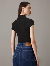 Remera negra de punto de viscosa elástica con textura de canalé irregular, corte slim, cuello perkins y mangas raglán cortas.