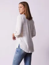 Blusa blanca texturizada marca Ninety, con cuello a la base, escote en V, abertura central con botones, bolsillo delantero y mangas tres cuartos regulables con presilla y botón.