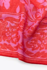 Pañuelo rectangular de lino color rojo con estampado floral en tonos rosados.