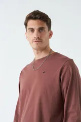 Remera manga larga color ladrillo, de corte clásico, con cuello redondo y logo bordado en el pecho.