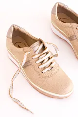 Zapatillas deportivas acordonadas color beige con suela de plataforma blanca y detalles en color plata.