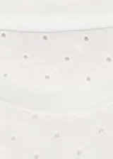 Camiseta blanca de algodón con cuello redondo, mangas cortas y diseño calado con bordado de lunares.