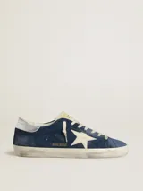 Zapatillas urbanas Golden Goose modelo Super-Star, color azul con efecto desgastado, estrella blanca en el lateral, talón plateado y cordones blancos.