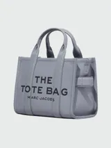 Bolso tote pequeño de cuero color negro, con doble asa corta y correa lateral. Estampado frontal con el nombre de la marca y el tipo de bolso.