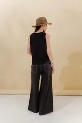 Pantalón de jean azul con corte sastrero de tiro medio bajo confeccionado en 100% algodón. Presenta cortes en los costados, dos bolsillos delanteros y dos traseros.