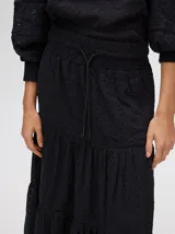 Falda larga blanca de broderie de algodón con detalle de galones con transparencias, pretina elástica con cordones ajustables y forro jacquard.