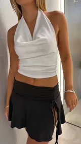 Minifalda negra de lycra con tajo lateral y frunce ajustable.