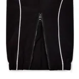 Conjunto deportivo negro con vivos blancos, compuesto por campera con cierre y pantalón con cordón ajustable. La campera tiene cuello alto, cierre frontal y logo de la marca bordado en el pecho. El pantalón tiene bolsillos laterales y logo bordado en la pierna.