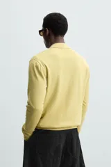 Polo de punto color amarillo claro, corte regular fit, tejido en hilatura con mezcla de algodón y lyocell. Cuello solapa con cierre frontal de botonadura y manga larga. Acabados en rib.