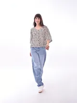 Blusa negra con cuello redondo y abotonadura frontal parcial. Tiene mangas cortas amplias y corte holgado.