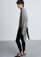 Sweater gris de tejido de punto fino, con cuello redondo, mangas largas y mangas decorativas.