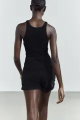 Bermuda de jean negro, tiro alto, corte mom fit, con trabillas y cinco bolsillos.