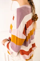 Sweater de rayas en tonos cálidos con escote redondo, cuello texturado y manga 3/4 de calce oversize.