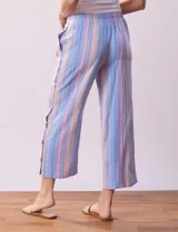 Pantalón capri de algodón a rayas verticales celestes, rosadas y beige. Tiene pretina elastizada, bolsillos delanteros y ruedo con botones.
