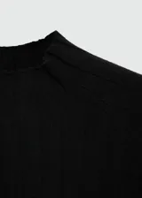 Jersey de punto fino negro, con cuello perkins, diseño entallado y manga larga.