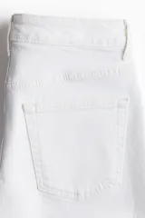 Short blanco de denim de algodón levemente elástico, con cinco bolsillos, tiro alto, corte relajado y cierre con botón.