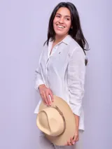 Camisa rosada de lino con cuello clásico, cierre frontal con botones, mangas largas con puños abotonados y logo bordado en el pecho.