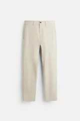 Pantalón de vestir color beige, corte slim fit, confeccionado en tejido elástico. Cuenta con bolsillos frontales y traseros de vivo con botón. Cierre frontal con cremallera y botón.