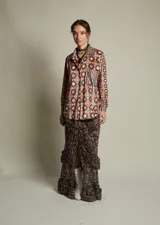 Camisa holgada de terciopelo elastizado con estampado floral y geométrico en tonos borgoña, amarillo y celeste. Corte clásico con cuello solapa y abotonada.