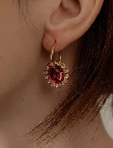 Par de aros dorados con dije circular de resina color terracota con glitter y borde de strass.